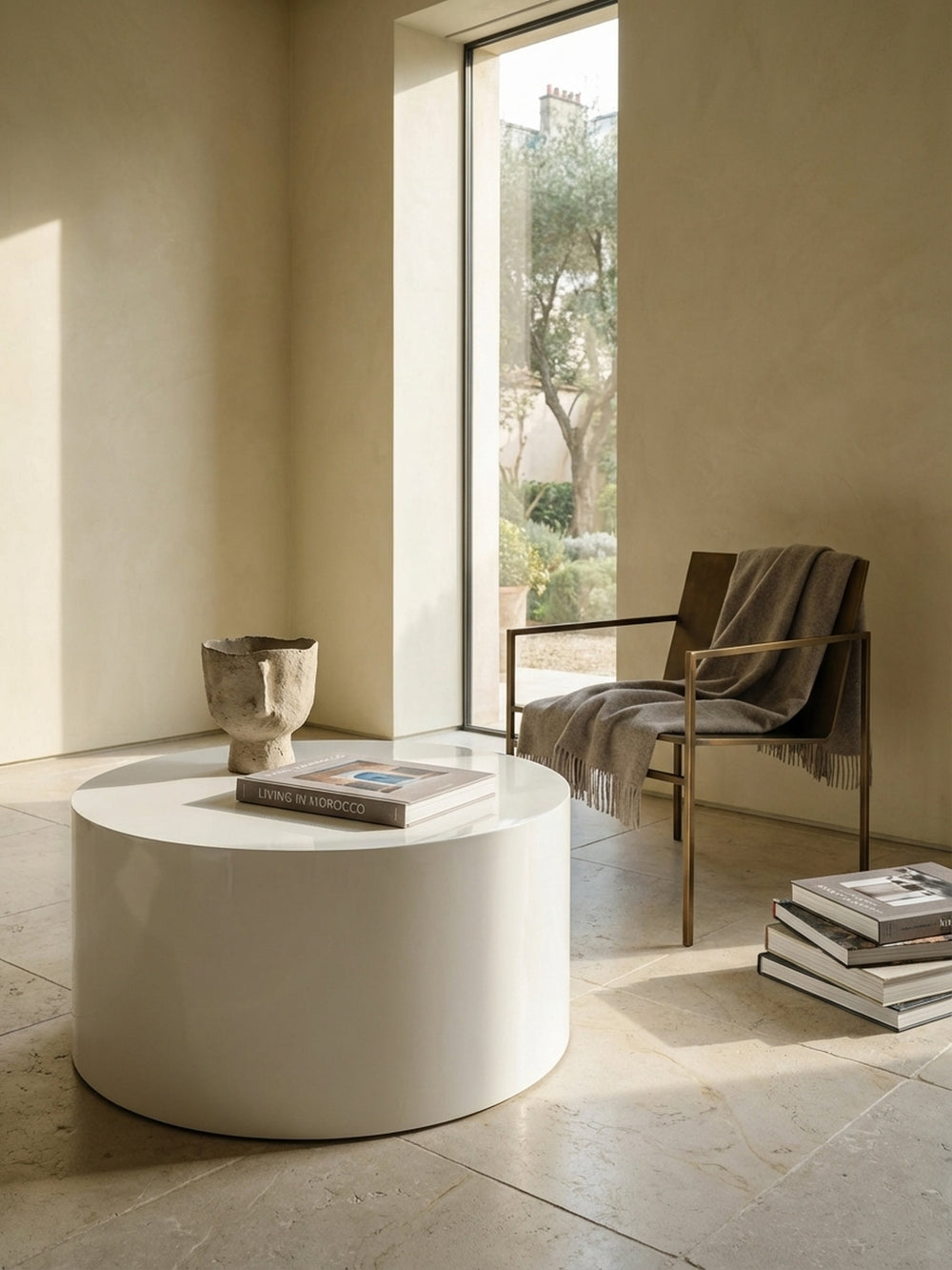 Der niedrige, runde Kaffeetisch in Weiß harmoniert perfekt mit einem modernen, beigefarbenen Bouclé-Sofa in einem hellen Wohnambiente._