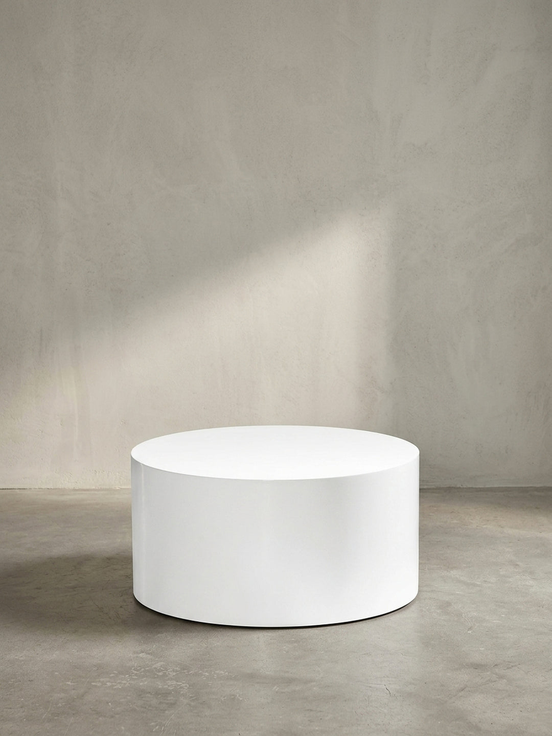 Der runde Design-Sofatisch in reinem Weiß als zeitloses und schickes Möbelstück für ein modernes und elegantes Wohnzimmer._