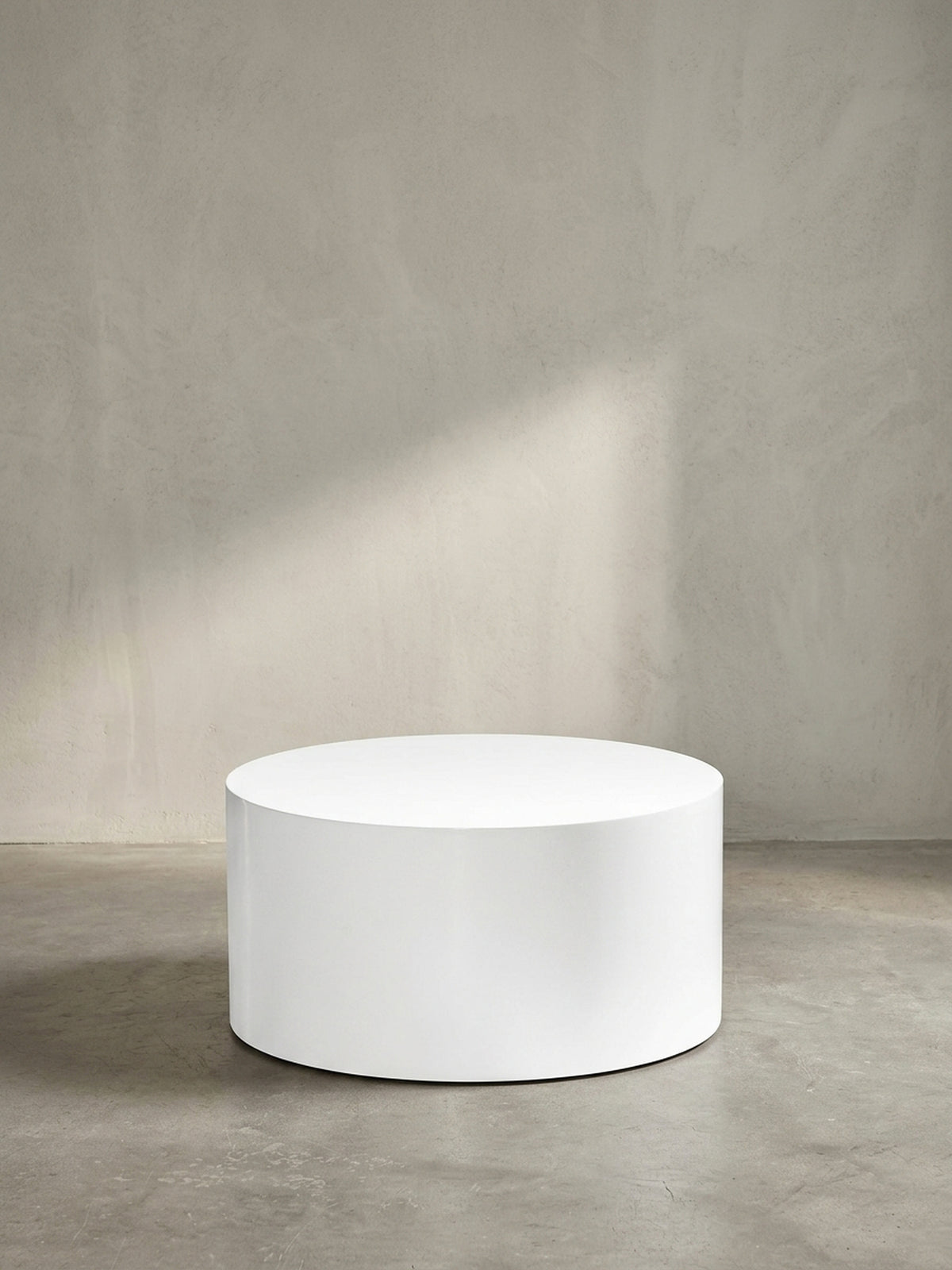Der runde Design-Sofatisch in reinem Weiß als zeitloses und schickes Möbelstück für ein modernes und elegantes Wohnzimmer._