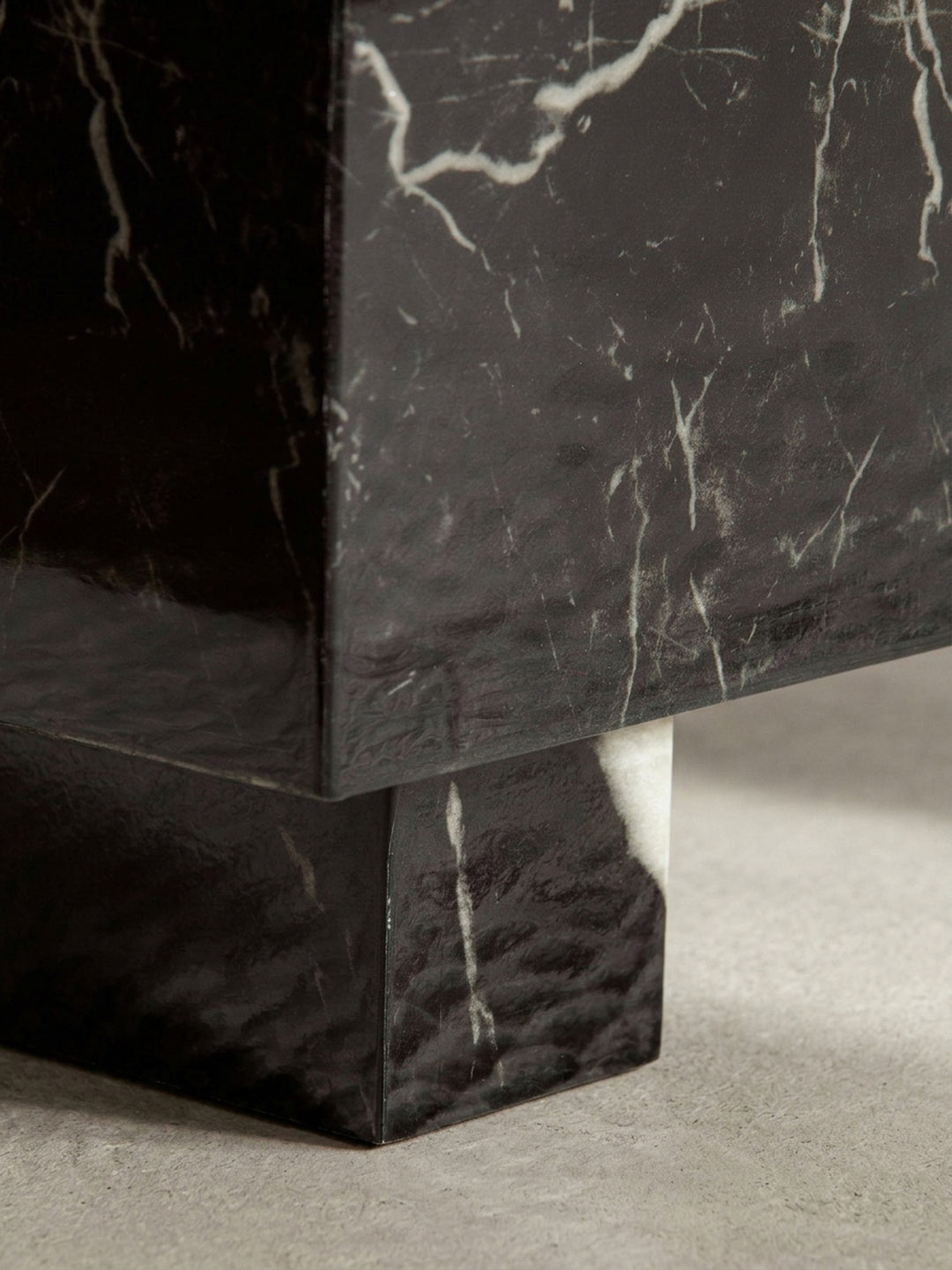 Leicht erhöhte Perspektive auf den Kaffeetisch, die die quadratische 60x60 cm Tischplatte in hochglänzender Marmor-Optik präsentiert._