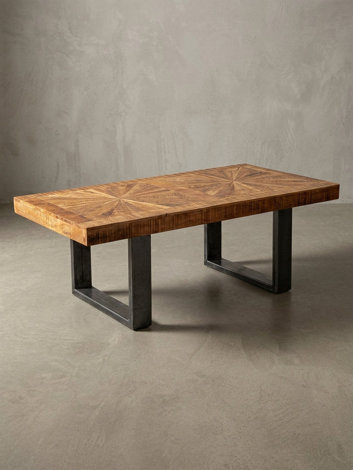 Freigestellter Couchtisch im Industrial Style von vorne. Der 40cm hohe Holztisch kombiniert eine honigfarbene Mangoholzplatte mit zwei robusten, dunkelgrauen Kufenbeinen aus Metall._