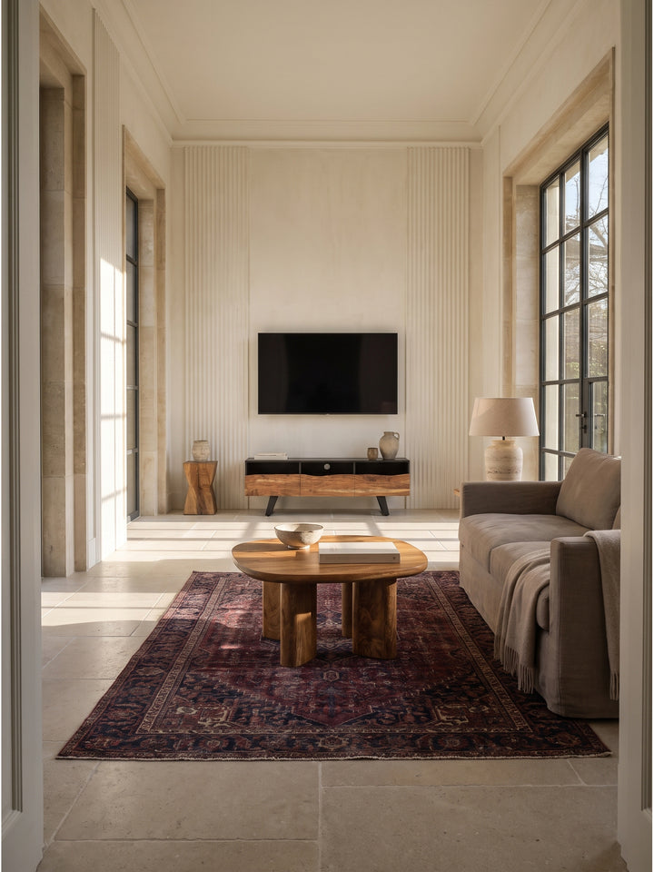 Massiver Couchtisch aus Mangoholz 60x60 cm als organischer Mittelpunkt im modernen Wohnzimmer auf sandfarbenem Wollteppich vor strukturierter Kalkputzwand._