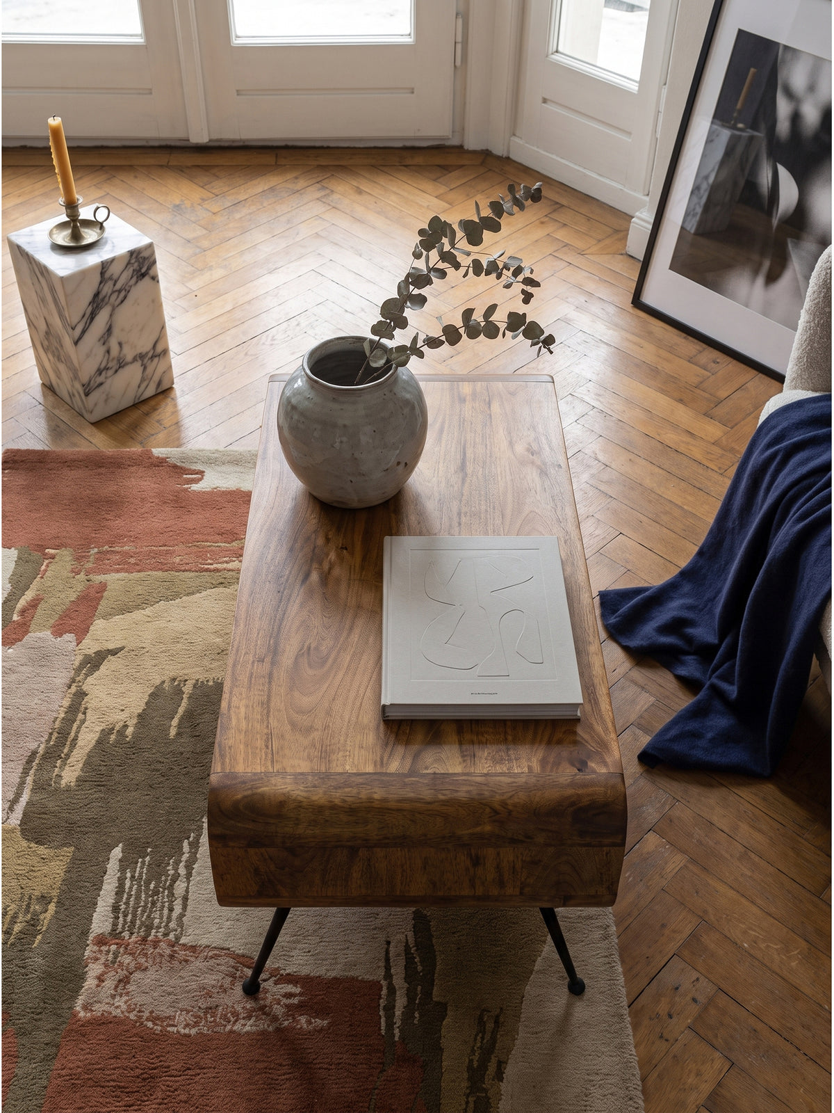 Draufsicht auf einen rechteckigen Couchtisch aus Massivholz mit runden Ecken auf einem indigoblauen Vintage-Teppich_