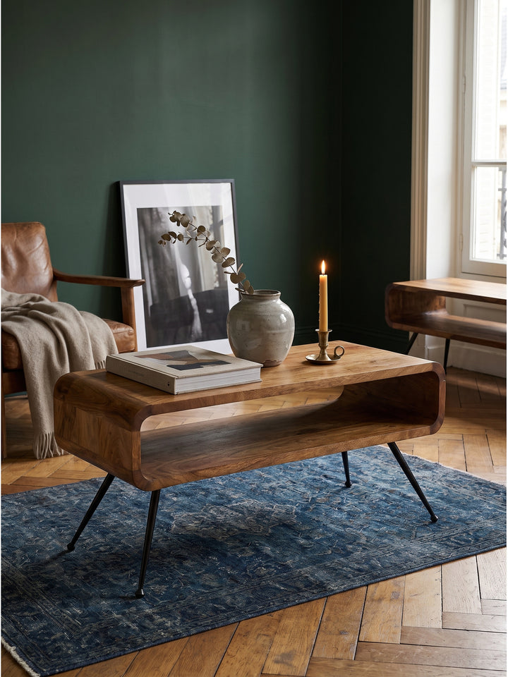 Wohnzimmer-Styling mit Couchtisch aus Mangoholz neben einem Leinensofa und antiken Messingkerzenhaltern_