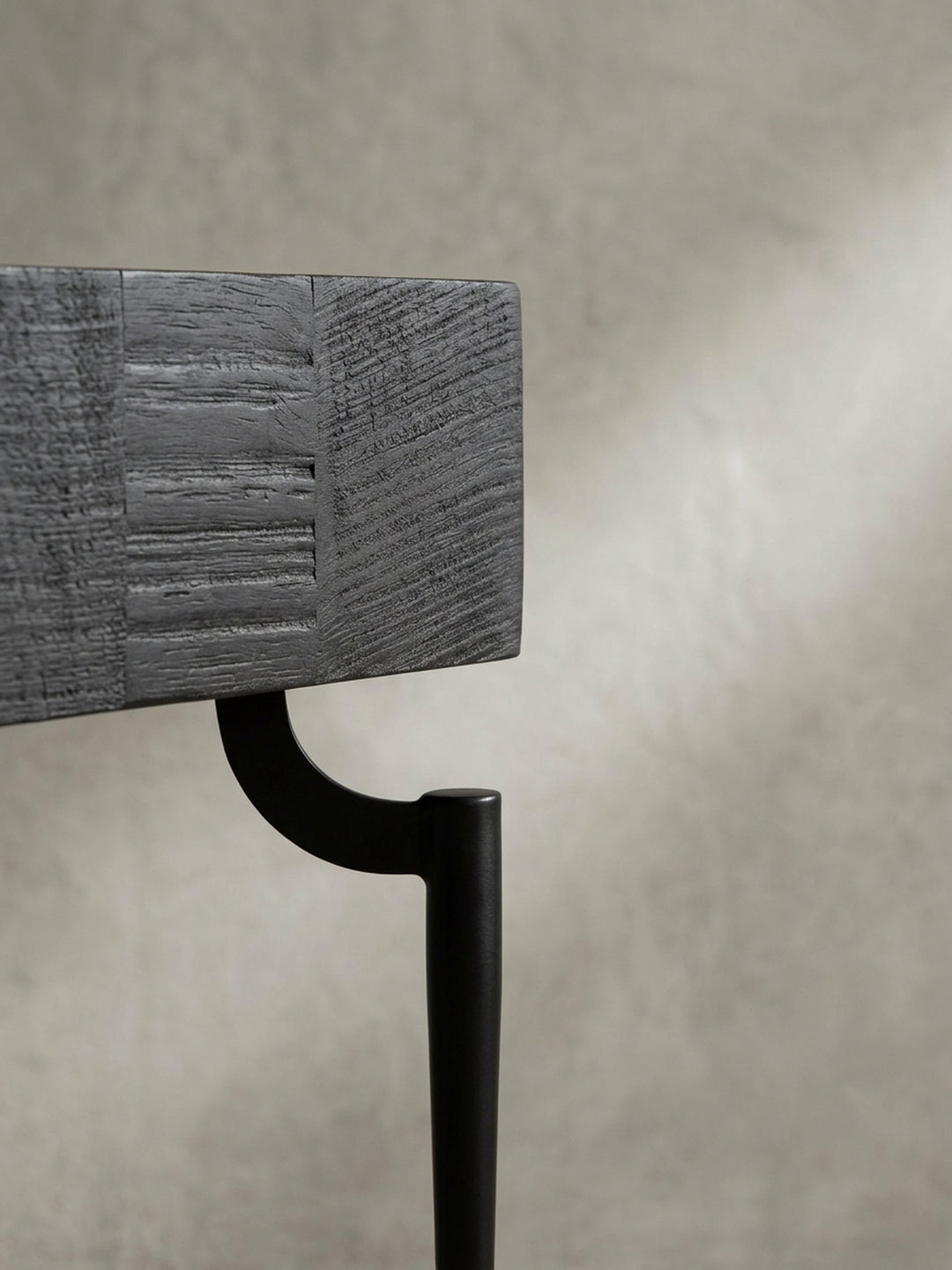 Detailaufnahme eines der elegant geschwungenen Metallbeine des schwarzen Couchtischs, das die hochwertige Verarbeitung zeigt._