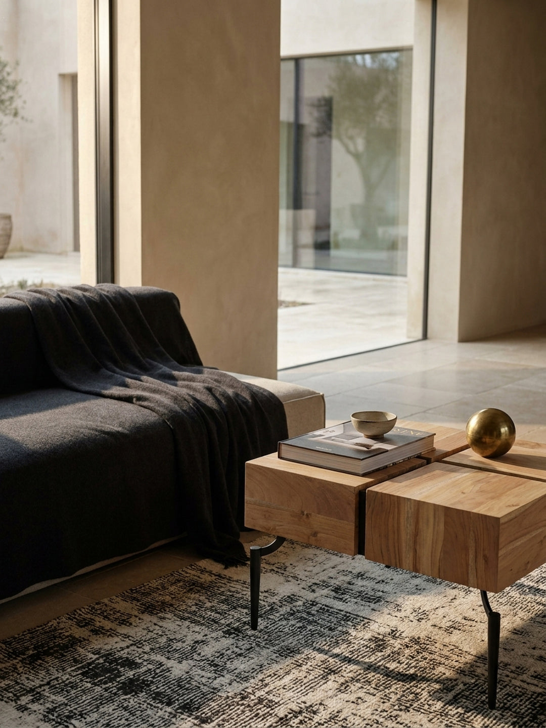 Der Holztisch mit schwarzem Metallgestell kombiniert mit einem beigefarbenen Sofa und einem Travertin-Beistelltisch, eine stilvolle Einrichtungsidee für das Wohnzimmer._