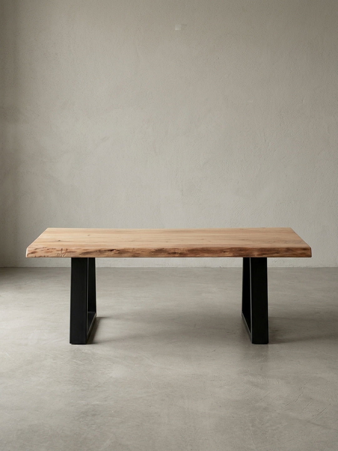 Couchtisch aus honigfarbenem Akazie-Massivholz auf neutralem Betonhintergrund Frontalansicht 60x115x40 cm_