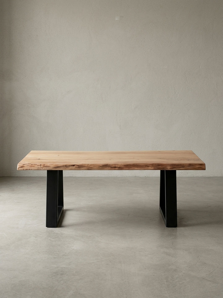 Couchtisch aus honigfarbenem Akazie-Massivholz auf neutralem Betonhintergrund Frontalansicht 60x115x40 cm_