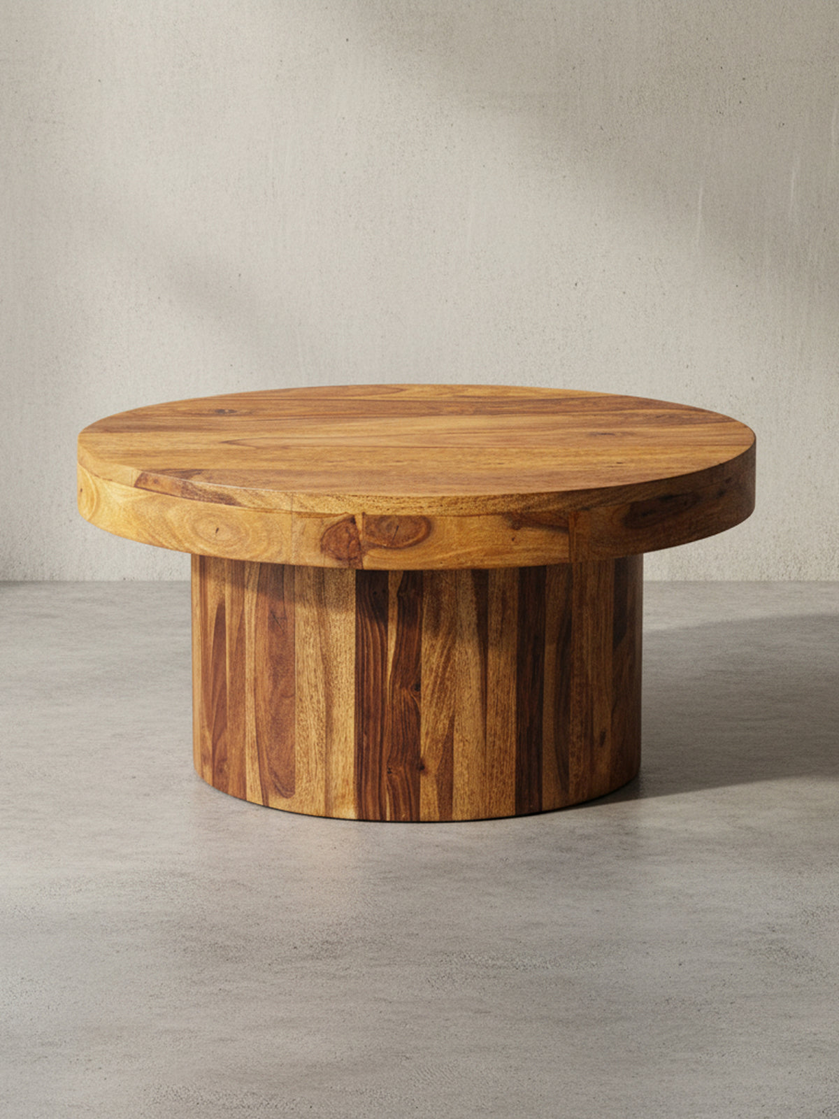 Runder Couchtisch (60x30 cm) aus massivem Sheesham-Holz mit Säulenfuß, freigestellt vor weißem Hintergrund, zeigt seine robuste und organische Form._