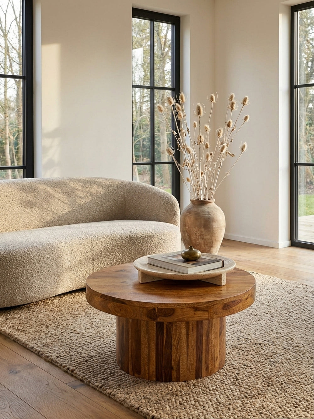 Von oben betrachtet, zeigt sich der runde Holztisch als harmonischer Mittelpunkt auf einem beigen Teppich, perfekt proportioniert für eine moderne Sofalandschaft._