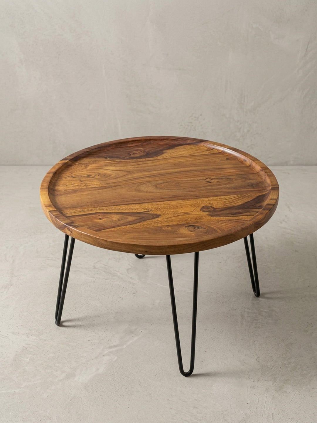 Alternativer Blickwinkel auf den Beistelltisch aus Holz und Metall. Das minimalistische Design mit runder Formensprache fügt sich harmonisch in hochwertige Einrichtungen ein._