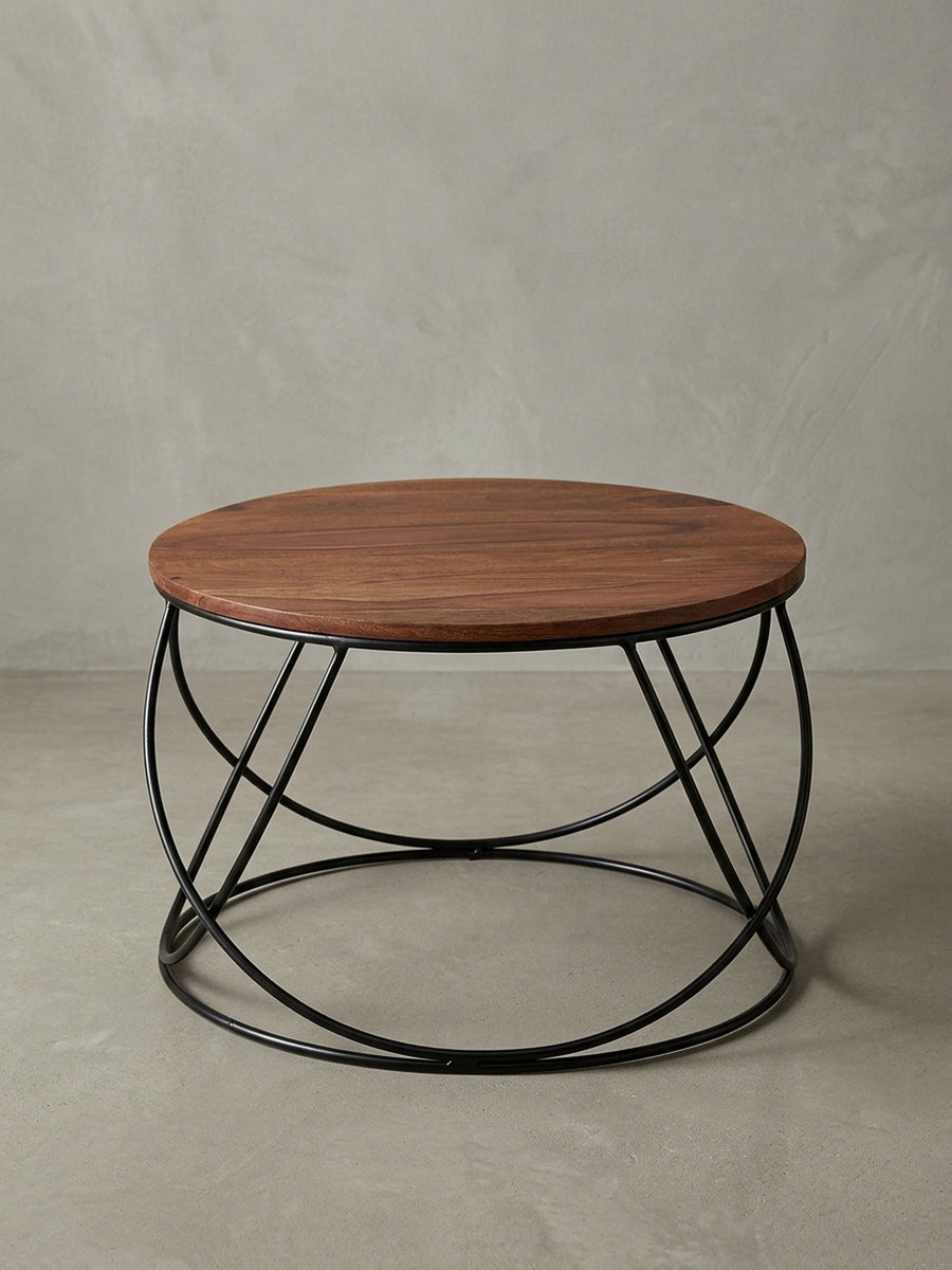 Frontansicht des runden Couchtischs (60x40cm) mit massiver Sheesham-Holzplatte und filigranem, schwarzem Metallgestell, freigestellt vor weißem Hintergrund._