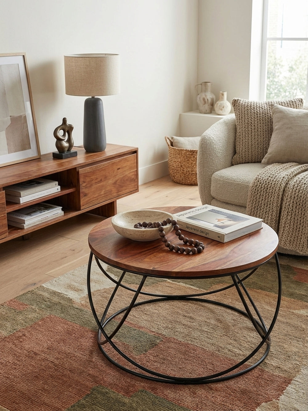 Von oben gesehen zeigt der massive Holztisch mit 60 cm Durchmesser seine runde Form und Maserung, perfekt arrangiert auf einem Teppich im modernen Wohnzimmer._