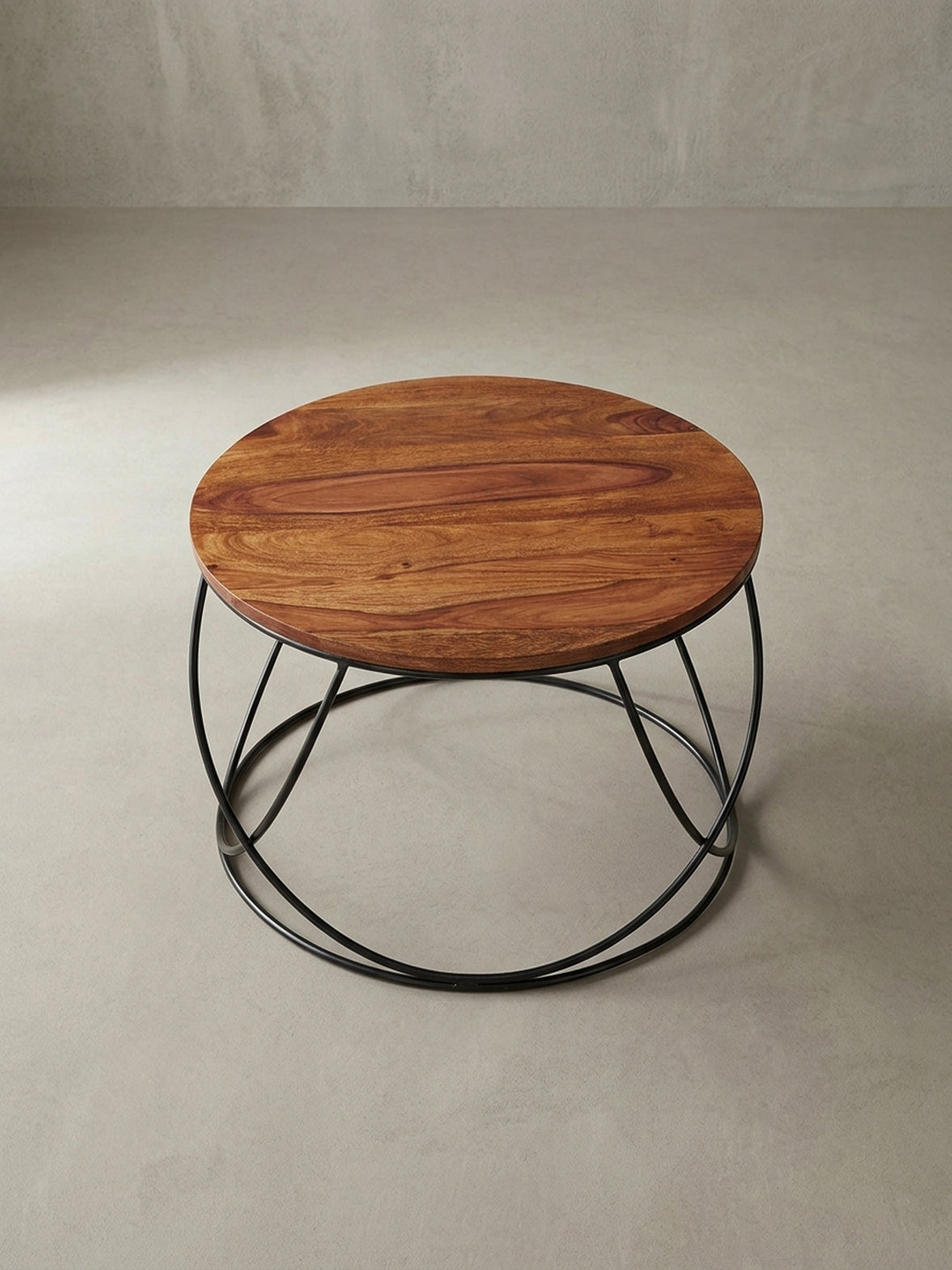 Perspektivische Ansicht des runden Wohnzimmertischs, die die luftige und offene Struktur des Designs hervorhebt und die massive Holzplatte schweben lässt._