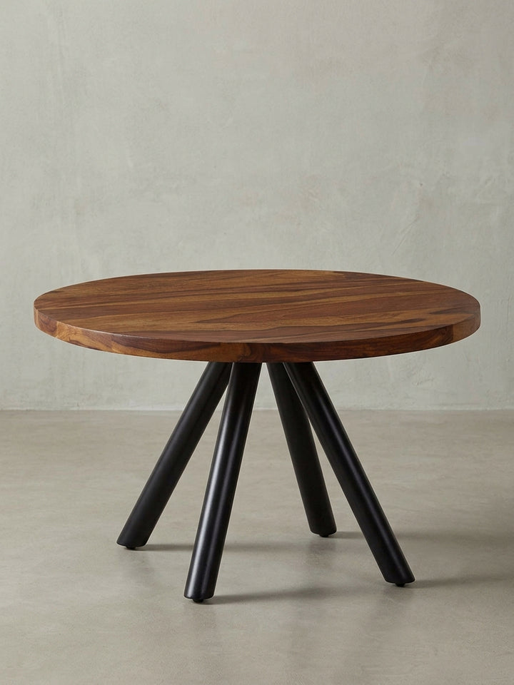Freigestellter Couchtisch 60x60x35 cm mit runder Sheesham Massivholzplatte und modernem Vierbein-Gestell aus schwarzem Metall._