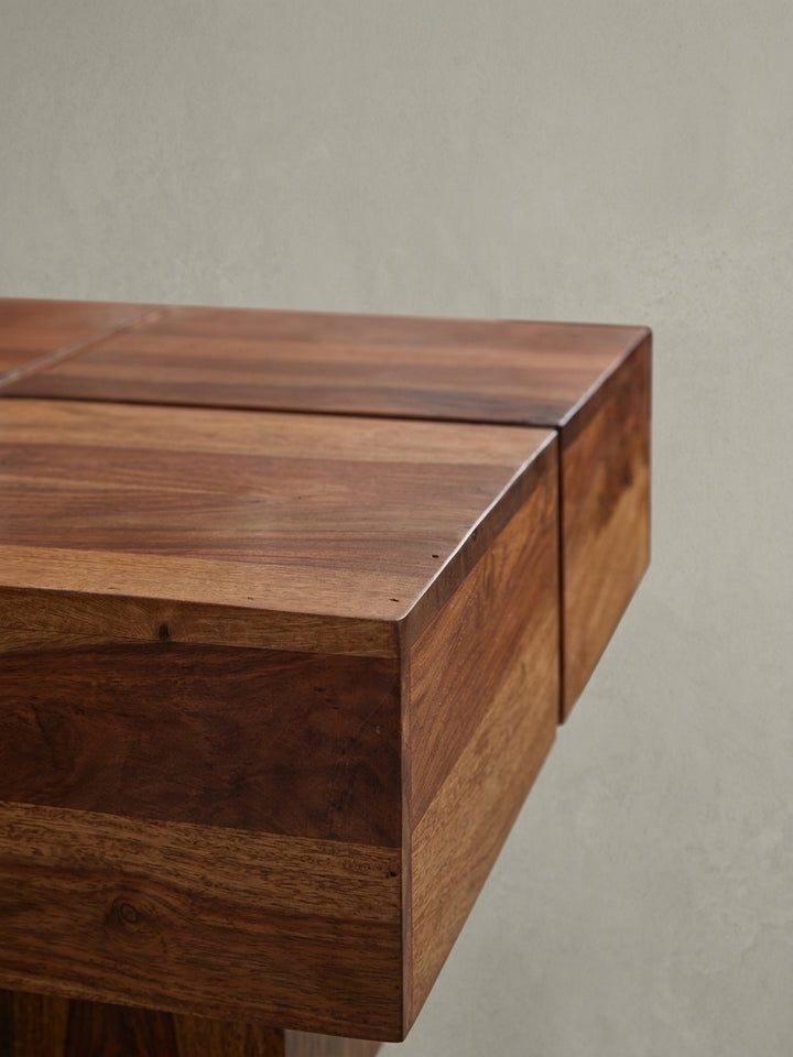 Nahaufnahme einer Ecke des massiven Couchtisches, die die saubere Kantenverarbeitung und die schützende Klarlack-Veredelung des Sheesham-Holzes zeigt._