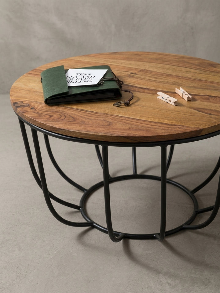 Eleganter Massivholztisch aus einem leicht erhöhten Winkel betrachtet. Das Zusammenspiel von naturbelassenem, braunem Sheesham und industriellem Metall strahlt puren Luxus aus._