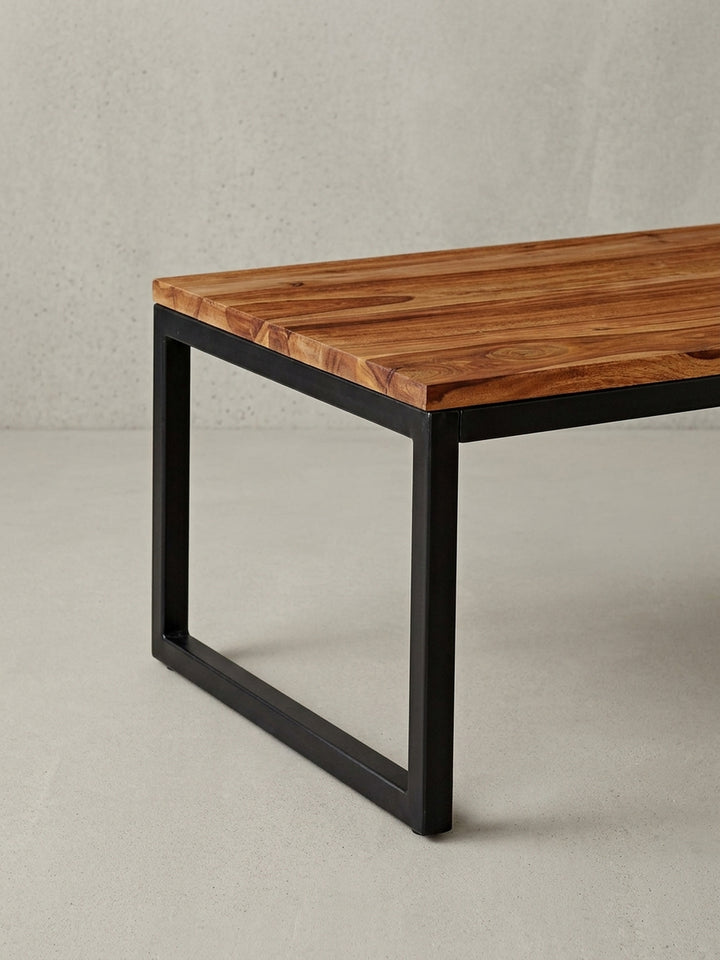 Detailaufnahme der Tischkante des massiven Couchtischs, die die natürliche Form und die hochwertige Verarbeitung des Sheesham Holzes zeigt._