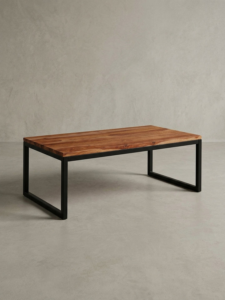 Gesamtüberblick des Couchtischs aus Massivholz und Metall, der das Zusammenspiel der warmen Holzoberfläche und des kühlen schwarzen Gestells darstellt._