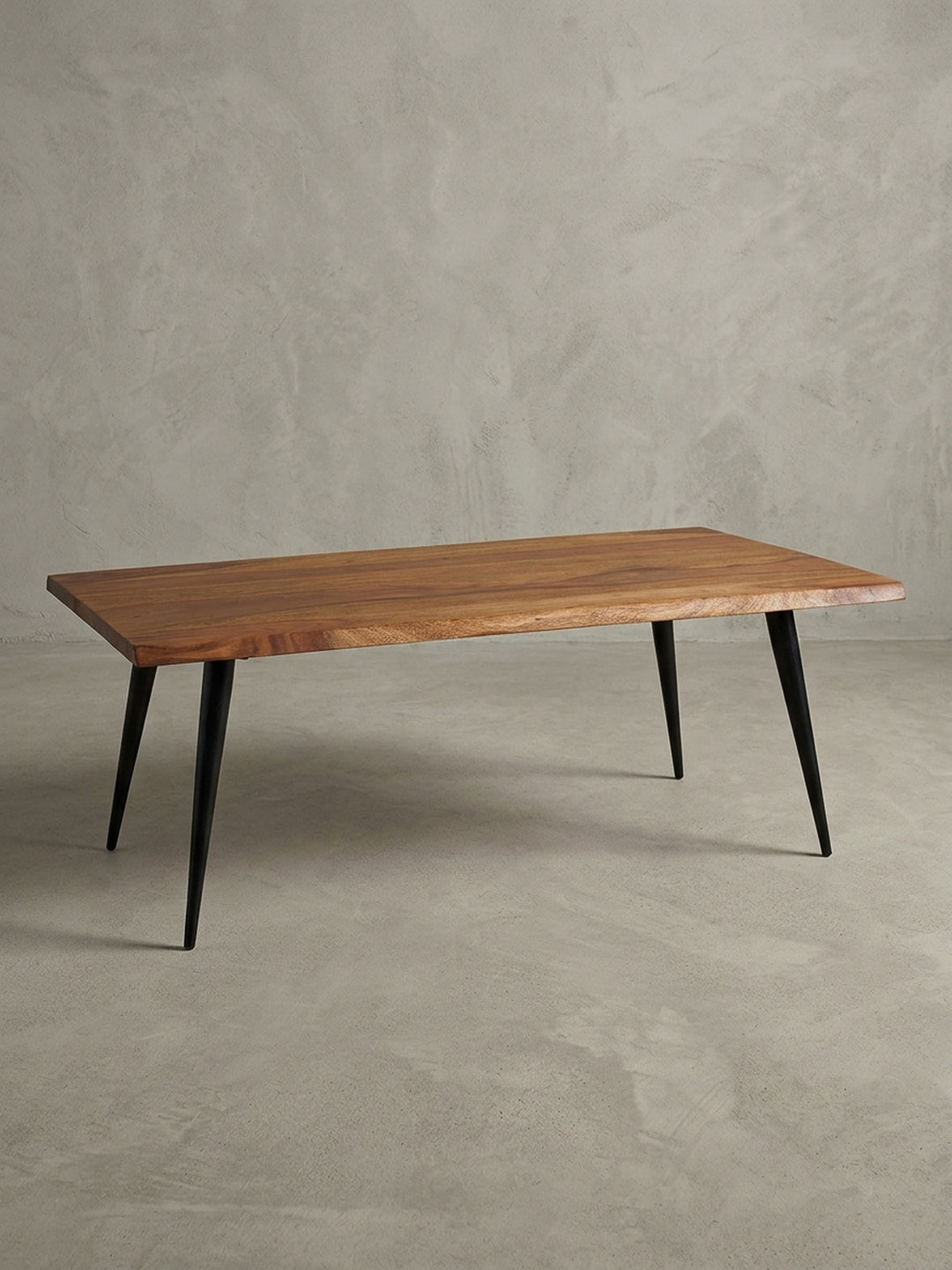 Eleganter Sofatisch aus massivem Sheesham-Holz mit schwarzen Metallbeinen, freigestellt auf weißem Hintergrund, Frontansicht des Designs._