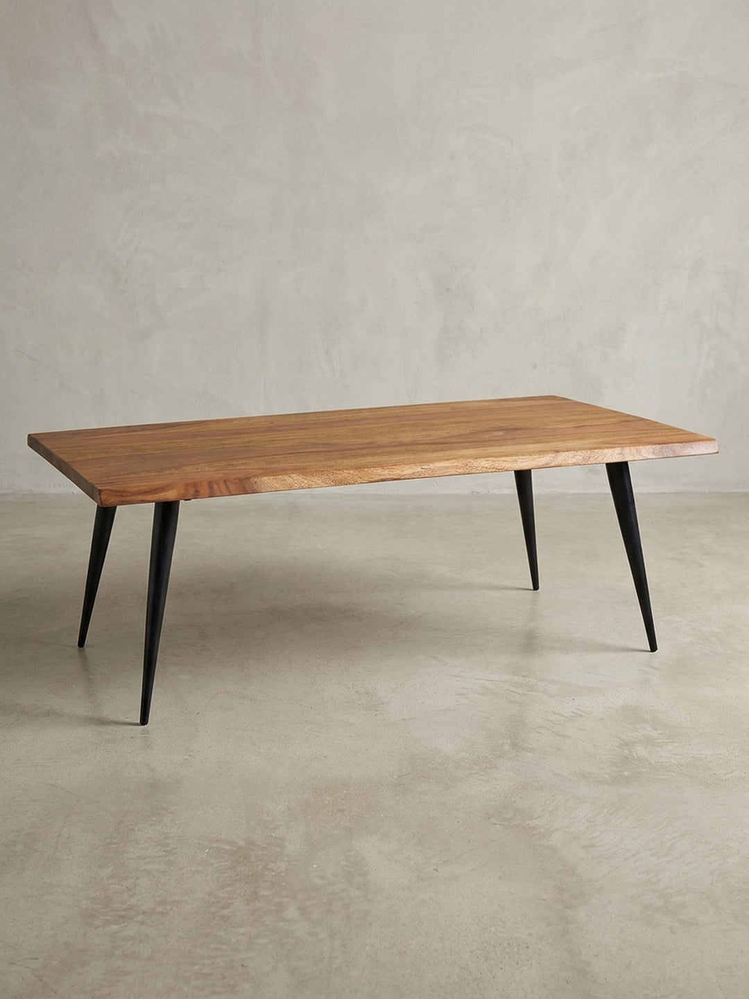 Gesamtüberblick des modernen Couchtischs mit Baumkante, der das zeitlose Design und die Materialkombination aus Sheeshamholz und Edelstahl darstellt._
