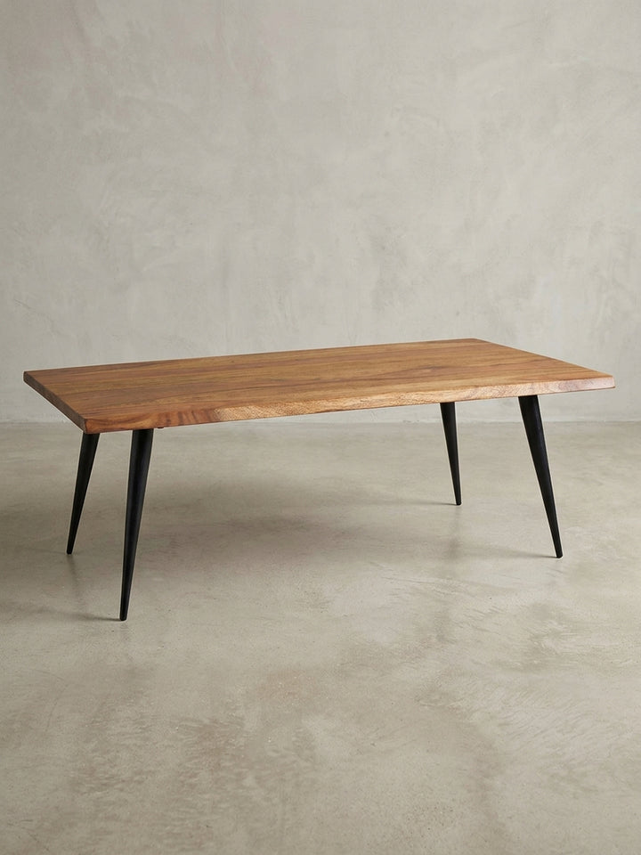Gesamtüberblick des modernen Couchtischs mit Baumkante, der das zeitlose Design und die Materialkombination aus Sheeshamholz und Edelstahl darstellt._