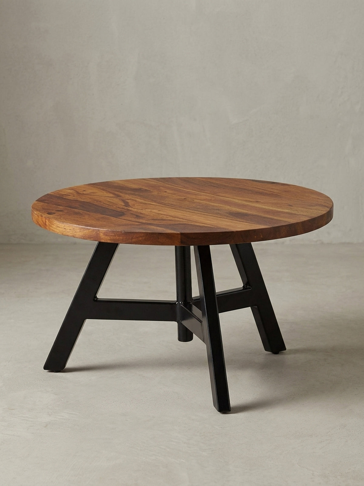 Design Wohnzimmertisch in 3/4-Ansicht, die massive 2,5 cm dicke Holzplatte und die geometrische Struktur des schwarzen Edelstahlgestells sind klar zu erkennen, Höhe 35 cm.