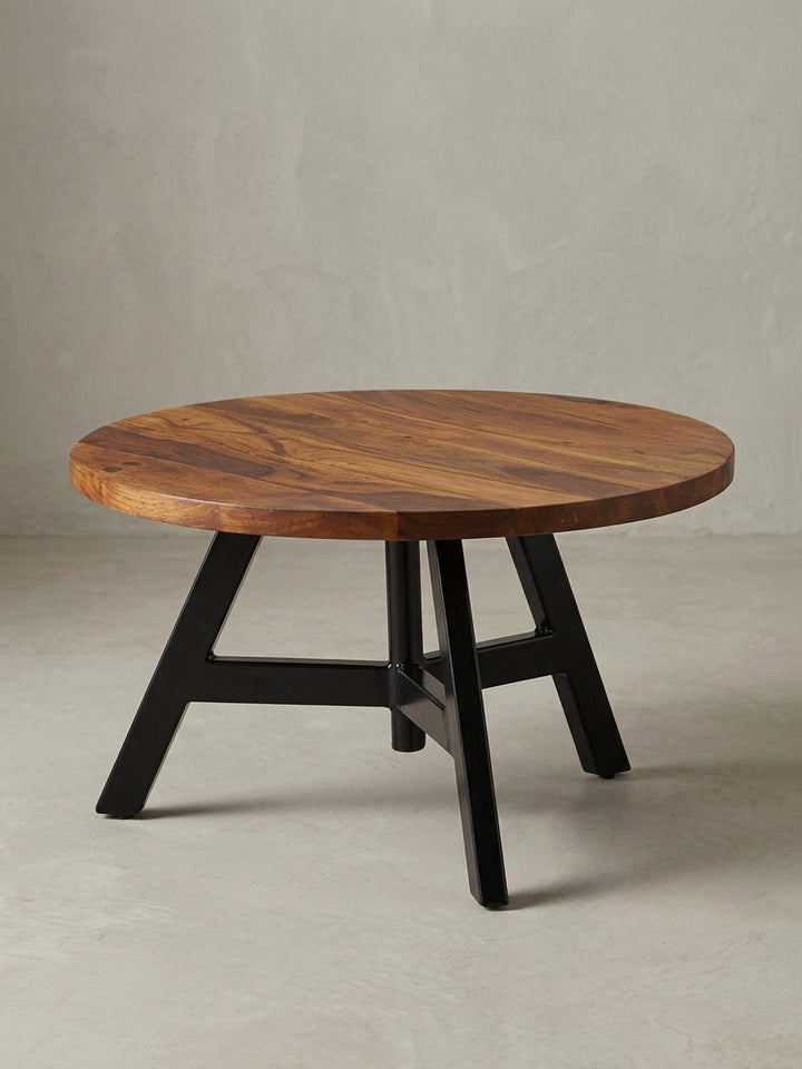 Design Wohnzimmertisch in 3/4-Ansicht, die massive 2,5 cm dicke Holzplatte und die geometrische Struktur des schwarzen Edelstahlgestells sind klar zu erkennen, Höhe 35 cm._
