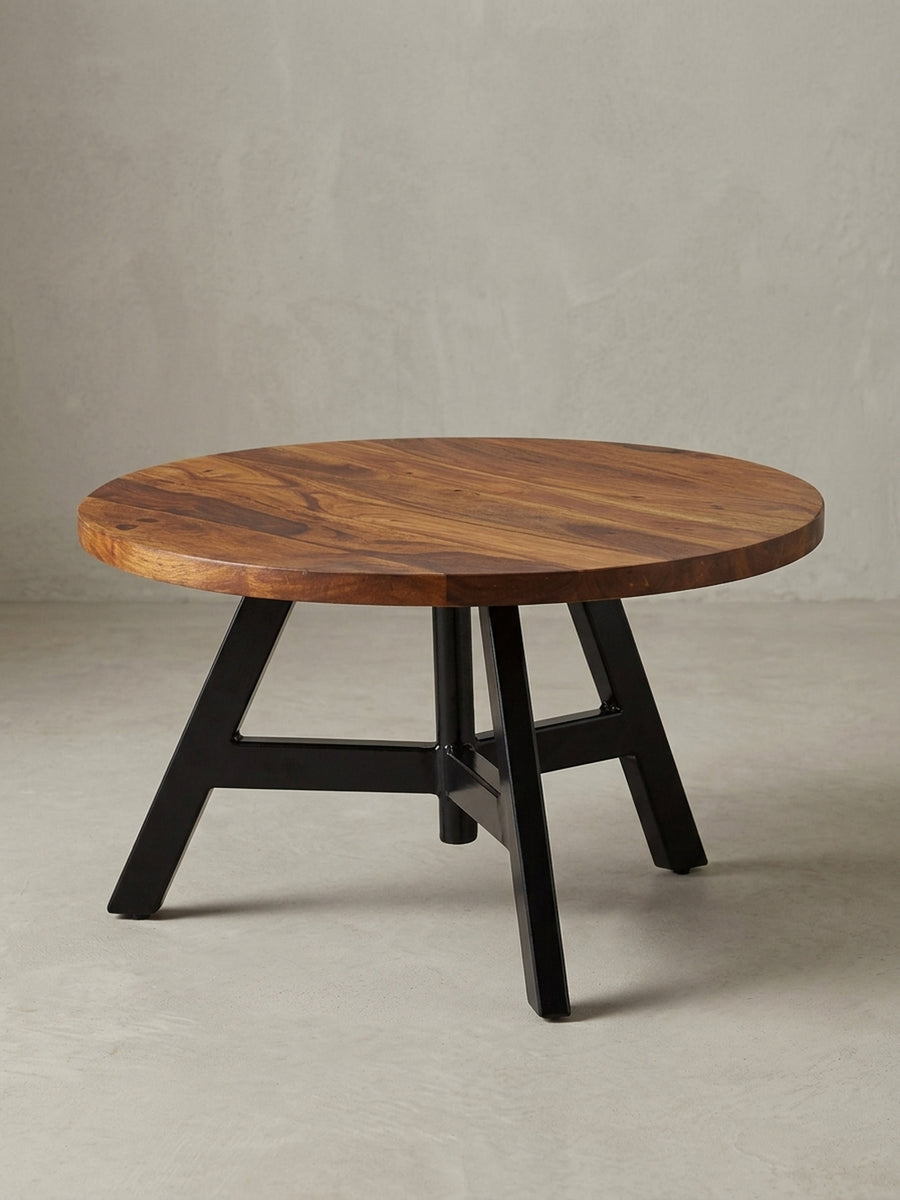 Design Wohnzimmertisch in 3/4-Ansicht, die massive 2,5 cm dicke Holzplatte und die geometrische Struktur des schwarzen Edelstahlgestells sind klar zu erkennen, Höhe 35 cm._