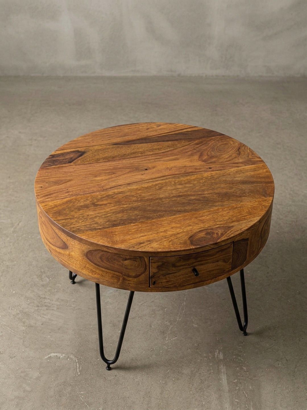 Alternative Perspektive des Sheesham Couchtischs, die die glatte, runde Tischplatte und die warme braune Farbgebung des hochwertigen Massivholzes deutlich hervorhebt._