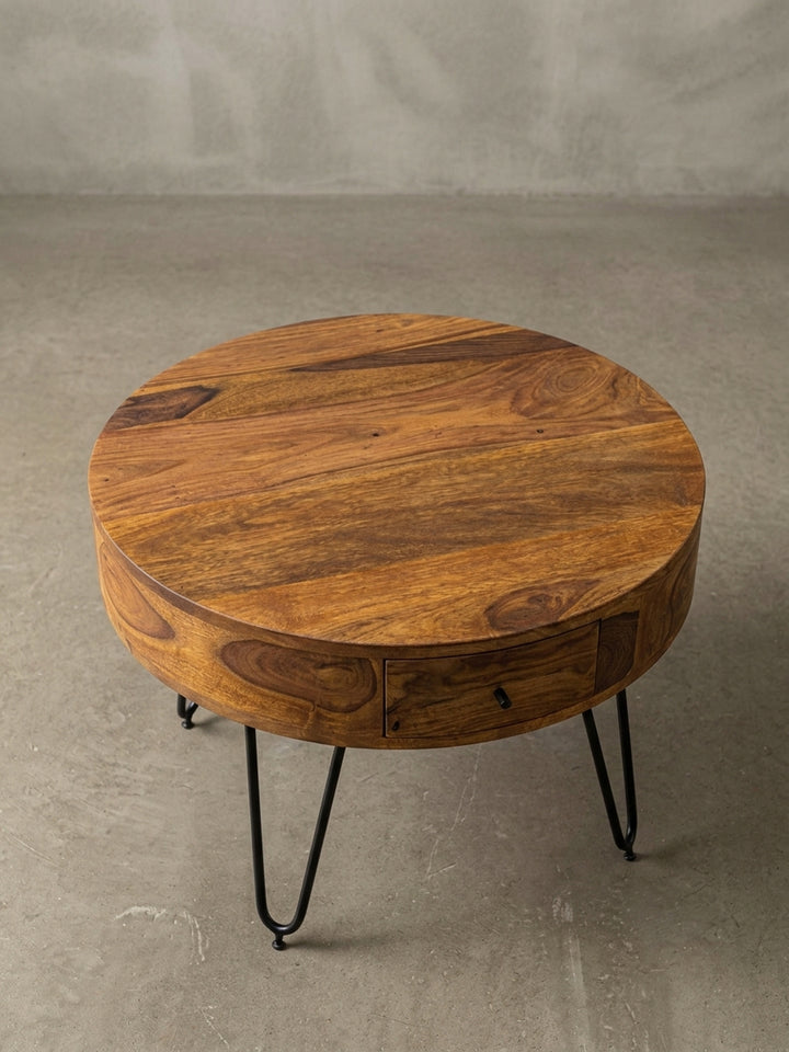 Alternative Perspektive des Sheesham Couchtischs, die die glatte, runde Tischplatte und die warme braune Farbgebung des hochwertigen Massivholzes deutlich hervorhebt._