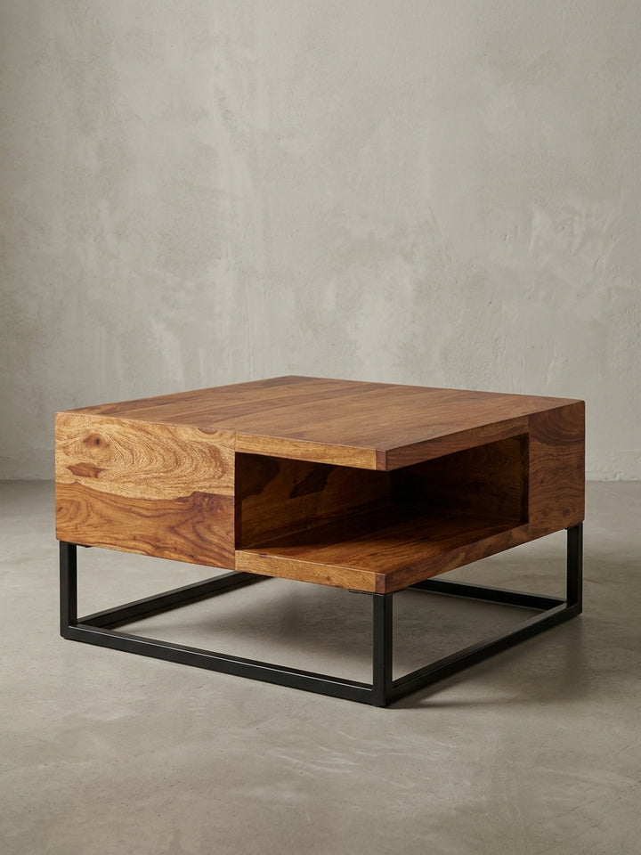 Schräge 3/4-Ansicht des Wohnzimmertisches, die das offene Staufach und die robuste Konstruktion aus Massivholz und pulverbeschichtetem Metall zeigt._