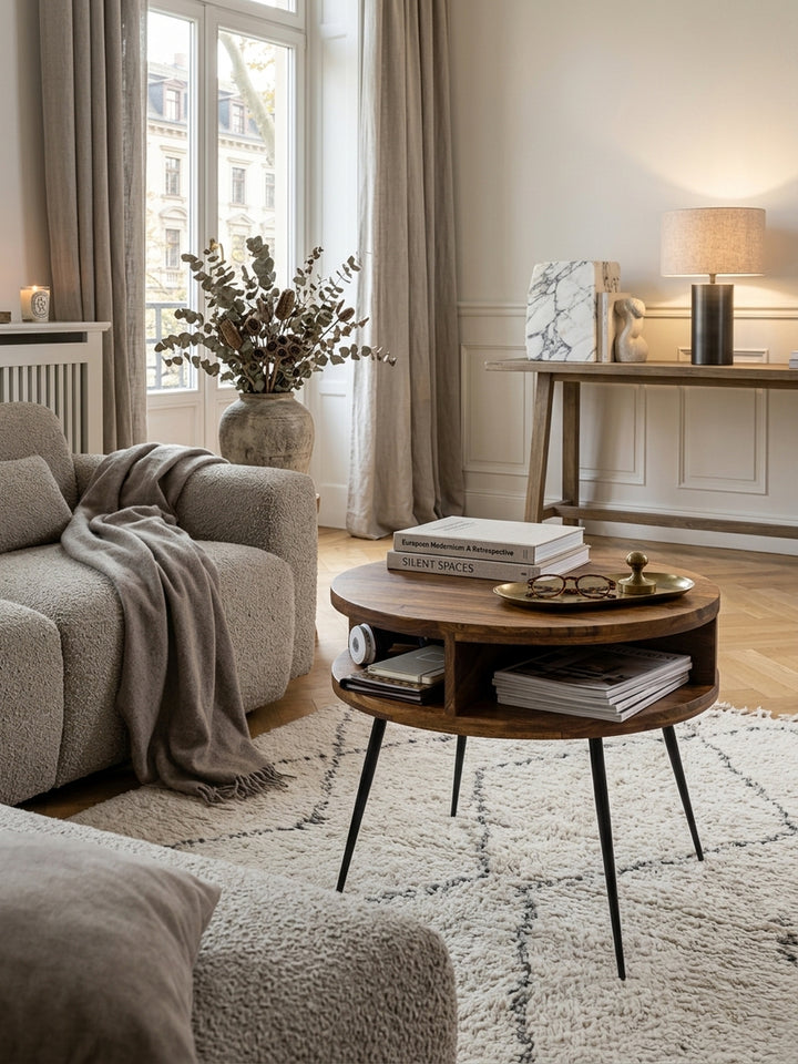 Runder Couchtisch Sheesham Massivholz 60cm in elegantem Wohnzimmer. Warme Holztöne harmonieren mit heller Einrichtung, Creme-Teppich und Retro-Design für modernes Quiet Luxury._