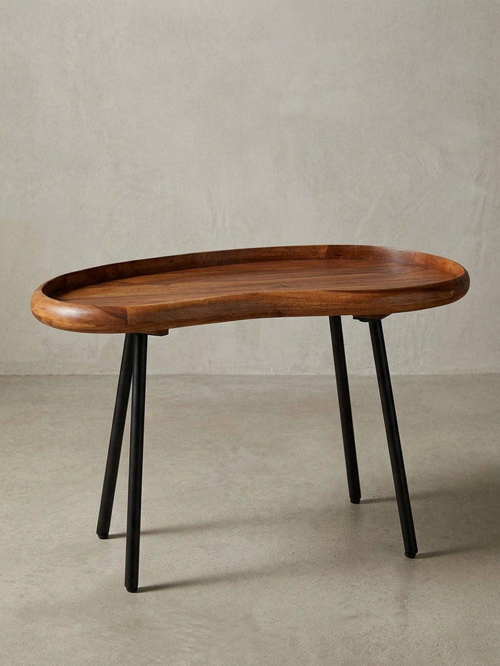 Kleiner Nierentisch im 50er Jahre Retro-Design freigestellt vor weißem Hintergrund. Der 71 cm breite Massivholz-Couchtisch besticht durch warme Holztöne und ausgestellte schwarze Beine._