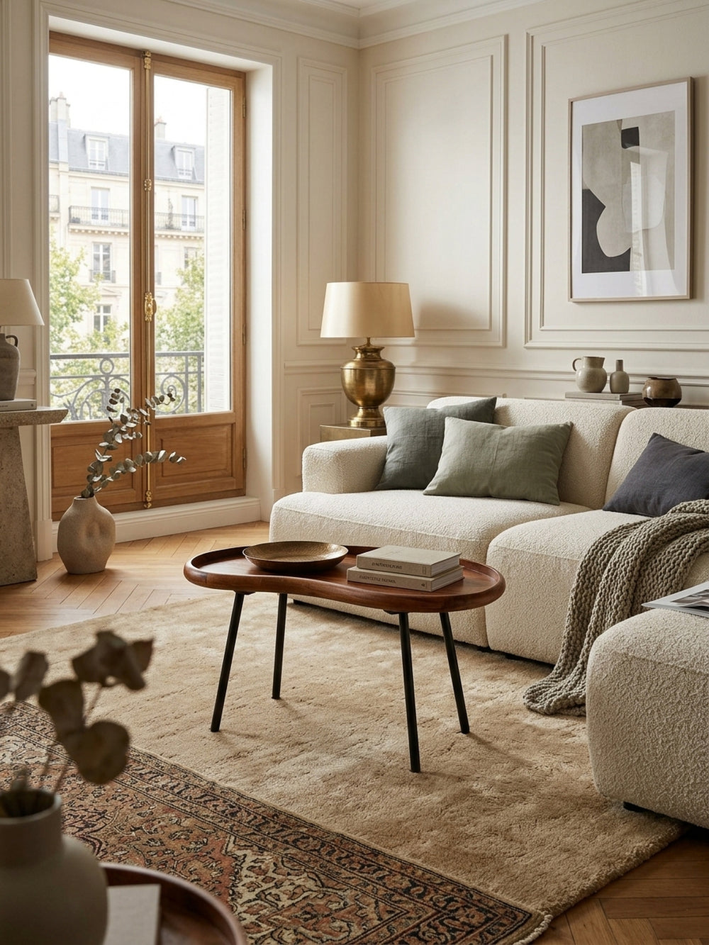 Nierenförmiger Couchtisch aus massivem Sheeshamholz in einem eleganten Wohnzimmer. Der organische Retro-Sofatisch (71x42x40 cm) mit schwarzen Metallbeinen steht auf einem hellen Wollteppich._