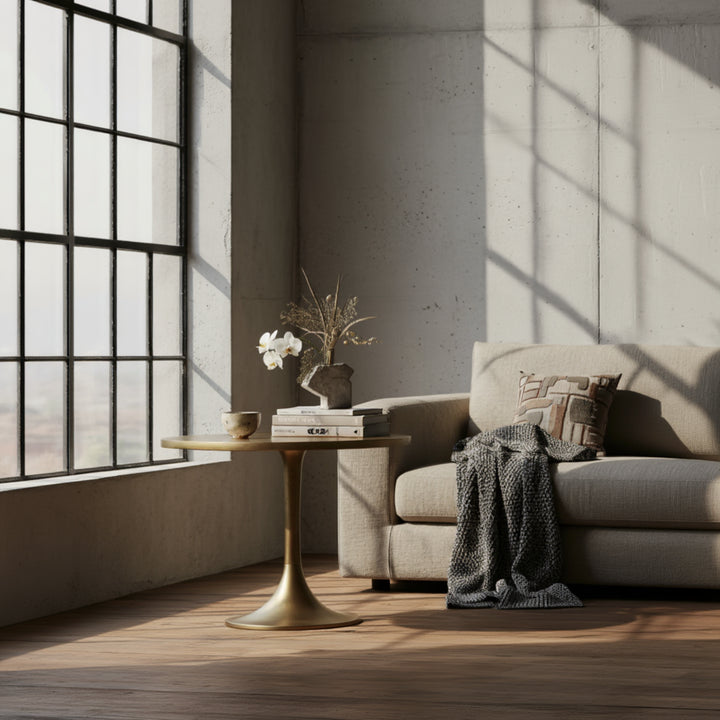 Design-Beistelltisch in Gold im minimalistischen Wohnzimmer mit grauem Sofa 