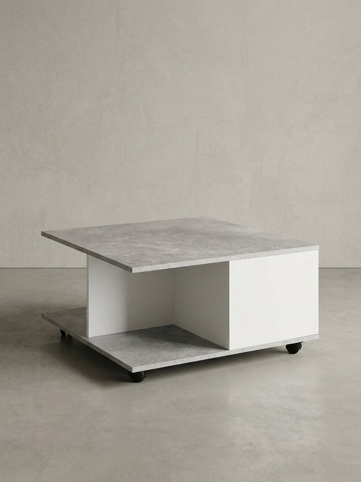 Funktionaler Couchtisch mit Rollen in Zementgrau und Weiß, Frontansicht mit offener und geschlossener Staufläche, freigestellt auf weißem Hintergrund._