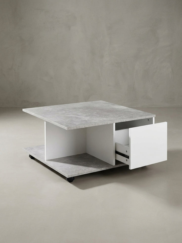 Nahaufnahme der grifflosen Schublade und der robusten Rollen des modernen Couchtisches, die sein praktisches und minimalistisches Design unterstreichen._