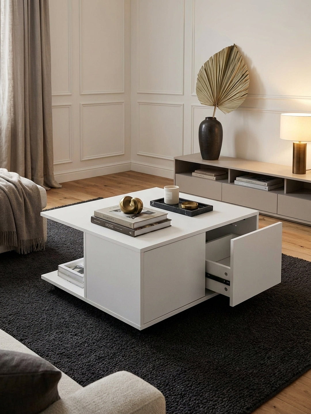 Moderner weißer Couchtisch 70x70 cm mit Rollen im eleganten Wohnzimmer, stilvoll dekoriert vor einem großen Sofa auf einem dunklen Teppich._