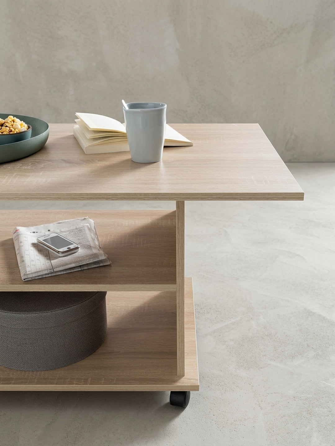 Nahaufnahme der leichtgängigen schwarzen Kunststoffrollen am Fuß des Wohnzimmertischs. Der mobile Sofatisch in Holzoptik lässt sich mühelos im Raum verschieben und neu platzieren._