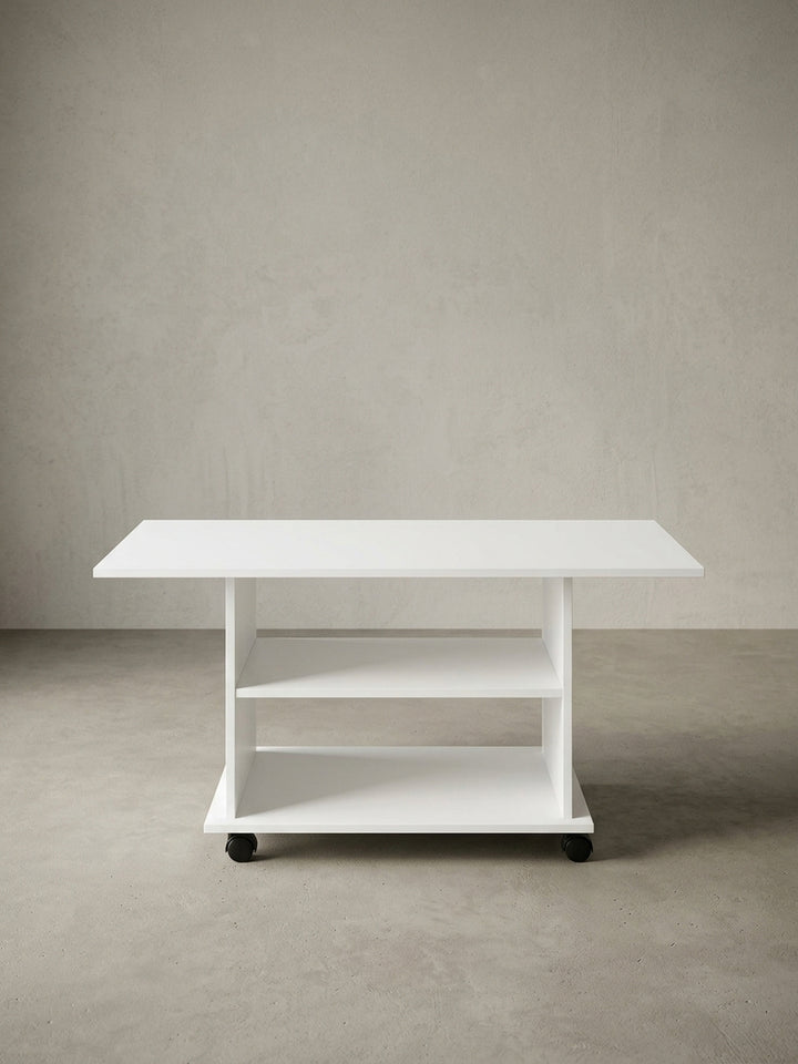Alternativer Winkel des weißen Loungetisches. Die rollbare Basis ermöglicht flexible Platzierung im Wohnraum, während das schlichte Holz-Design zu vielen Einrichtungsstilen passt._