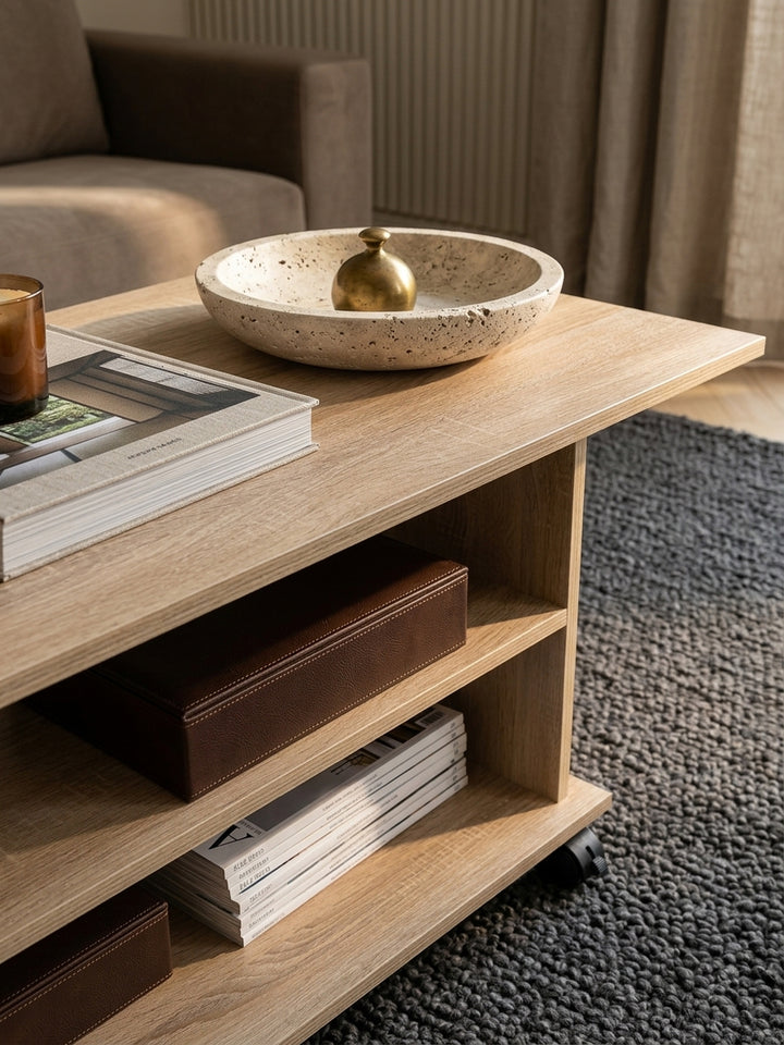 Detailaufnahme der kratzfesten Melaminharz-Oberfläche des Wohnzimmertischs. Die Sonoma Eiche Struktur des Holztischs zeigt eine natürliche Maserung für eine warme Atmosphäre._