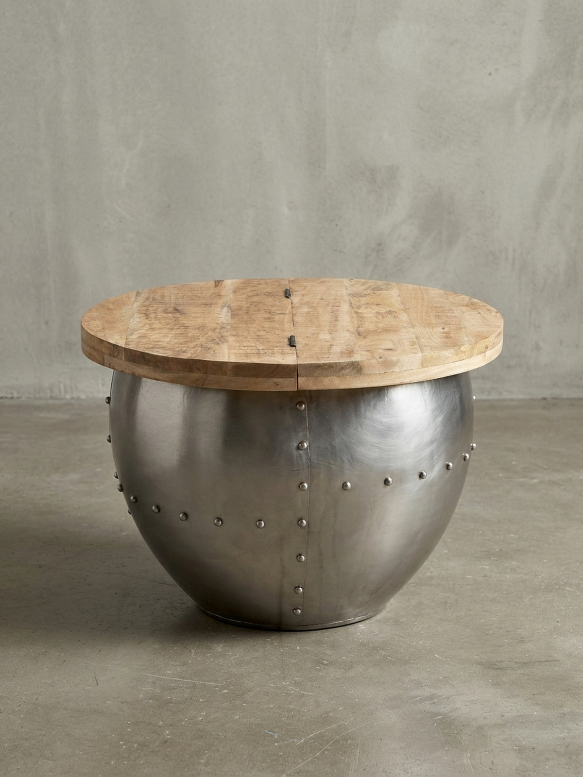 Profilansicht des runden Sofatisches, die die Höhe von 43 cm und die bauchige Form des silbernen Metallfußes im Industrial Style hervorhebt.