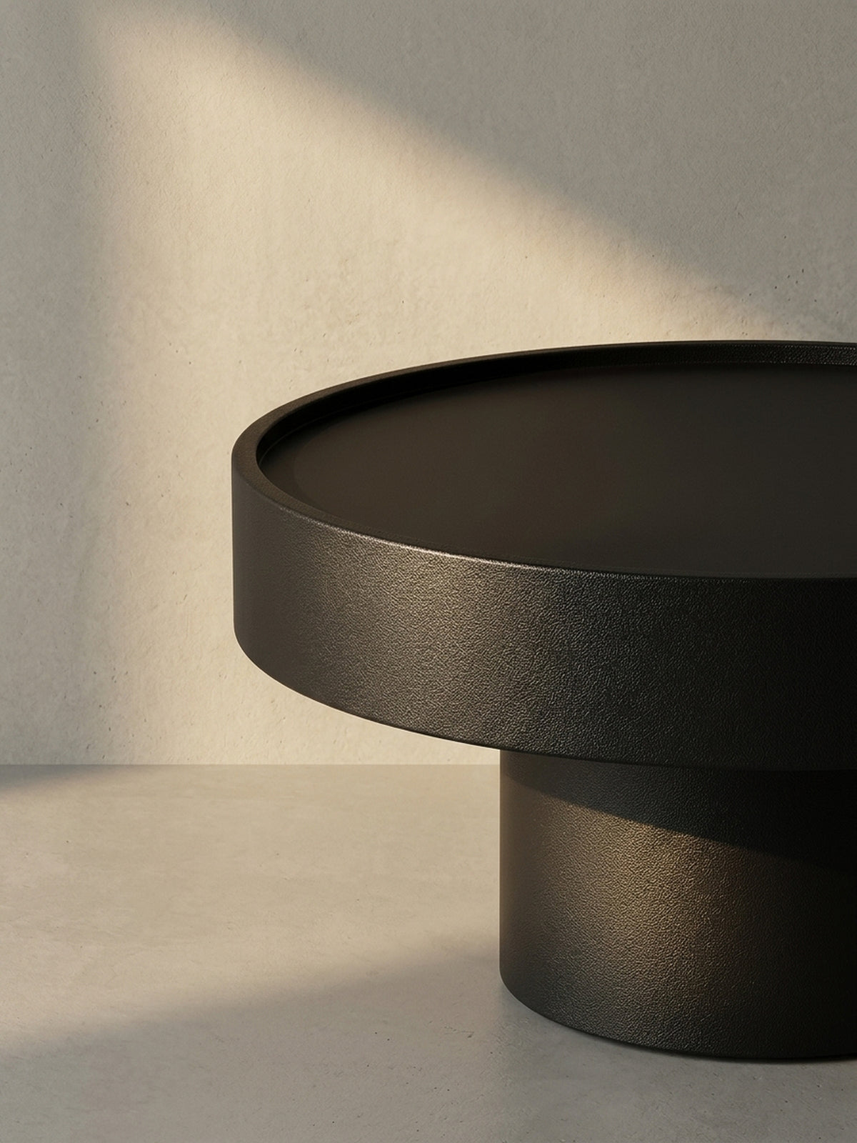 Der runde Beistelltisch aus schwarzem Metall in einer alternativen Perspektive, die seine minimalistische und moderne Form betont._