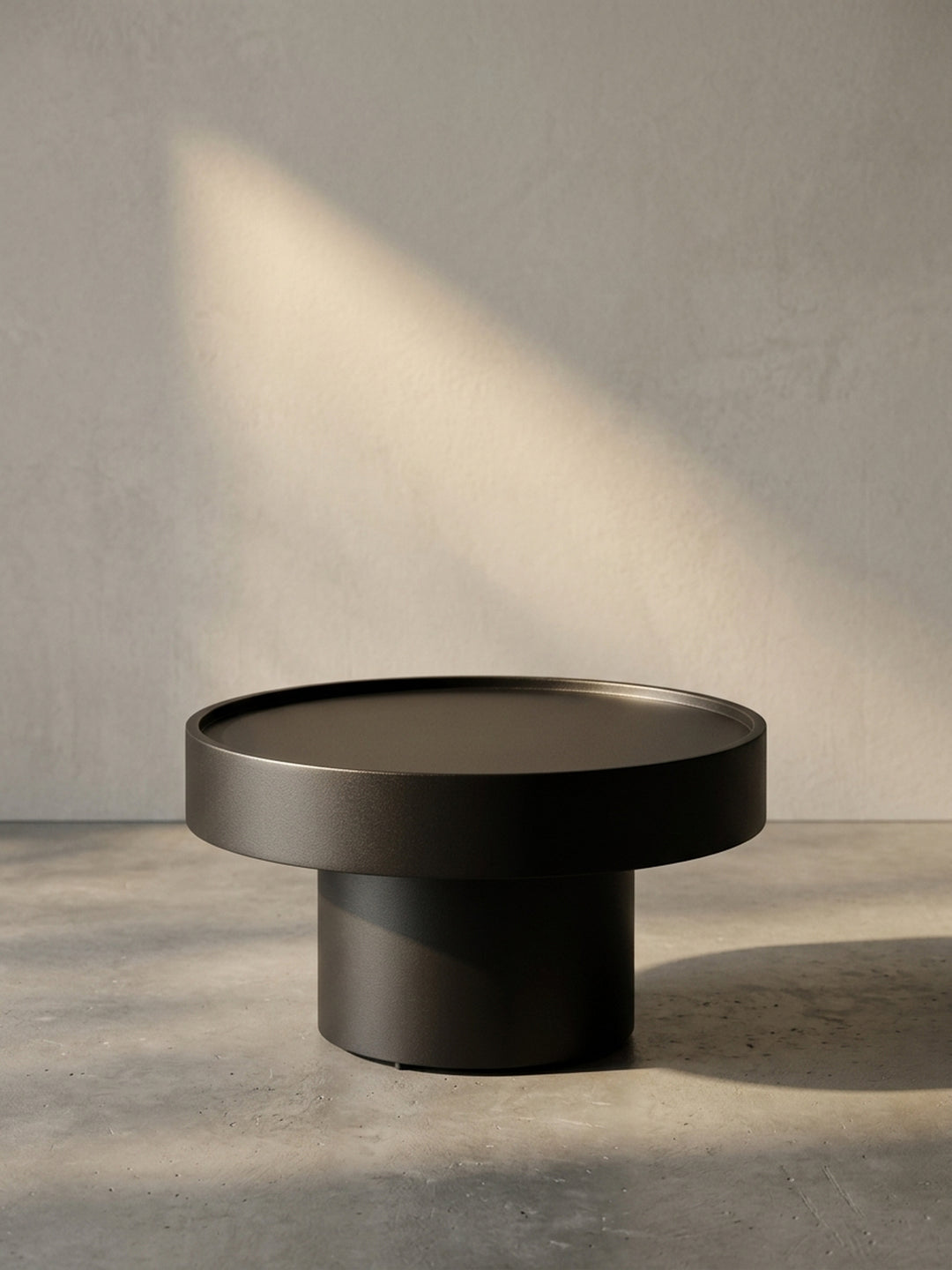 Frontansicht des runden, schwarzen Couchtischs aus Metall, seine skulpturale Pilz-Form ist vor weißem Hintergrund gut zu erkennen._