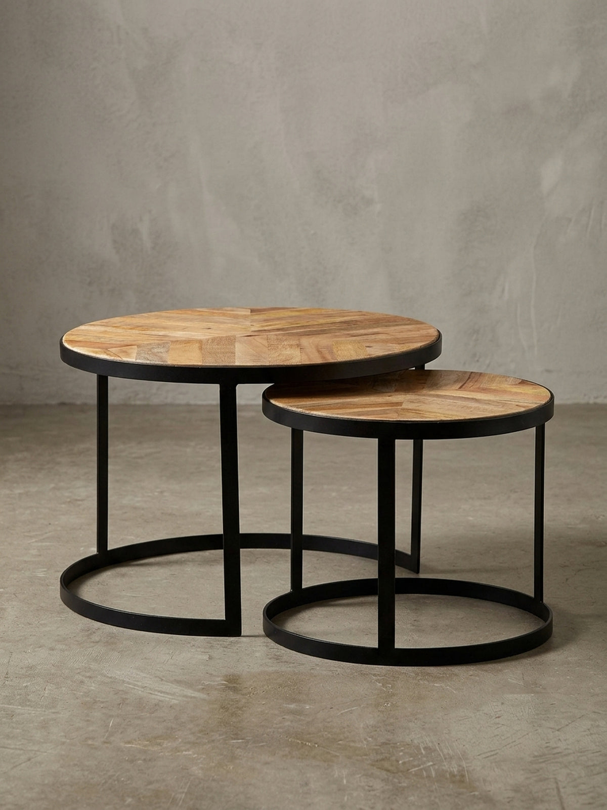 Profilansicht des zweiteiligen Couchtisch-Sets, das die schlanke Silhouette der schwarzen Metallgestelle und die Stärke der Massivholzplatten hervorhebt._