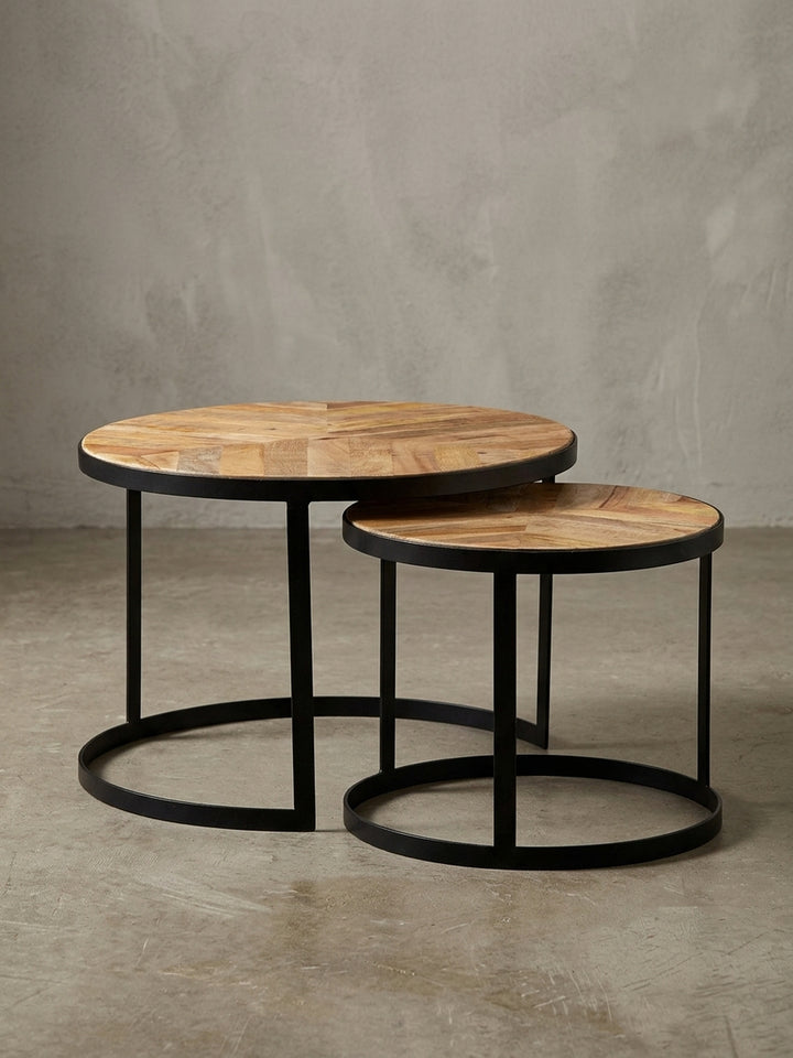 Profilansicht des zweiteiligen Couchtisch-Sets, das die schlanke Silhouette der schwarzen Metallgestelle und die Stärke der Massivholzplatten hervorhebt._