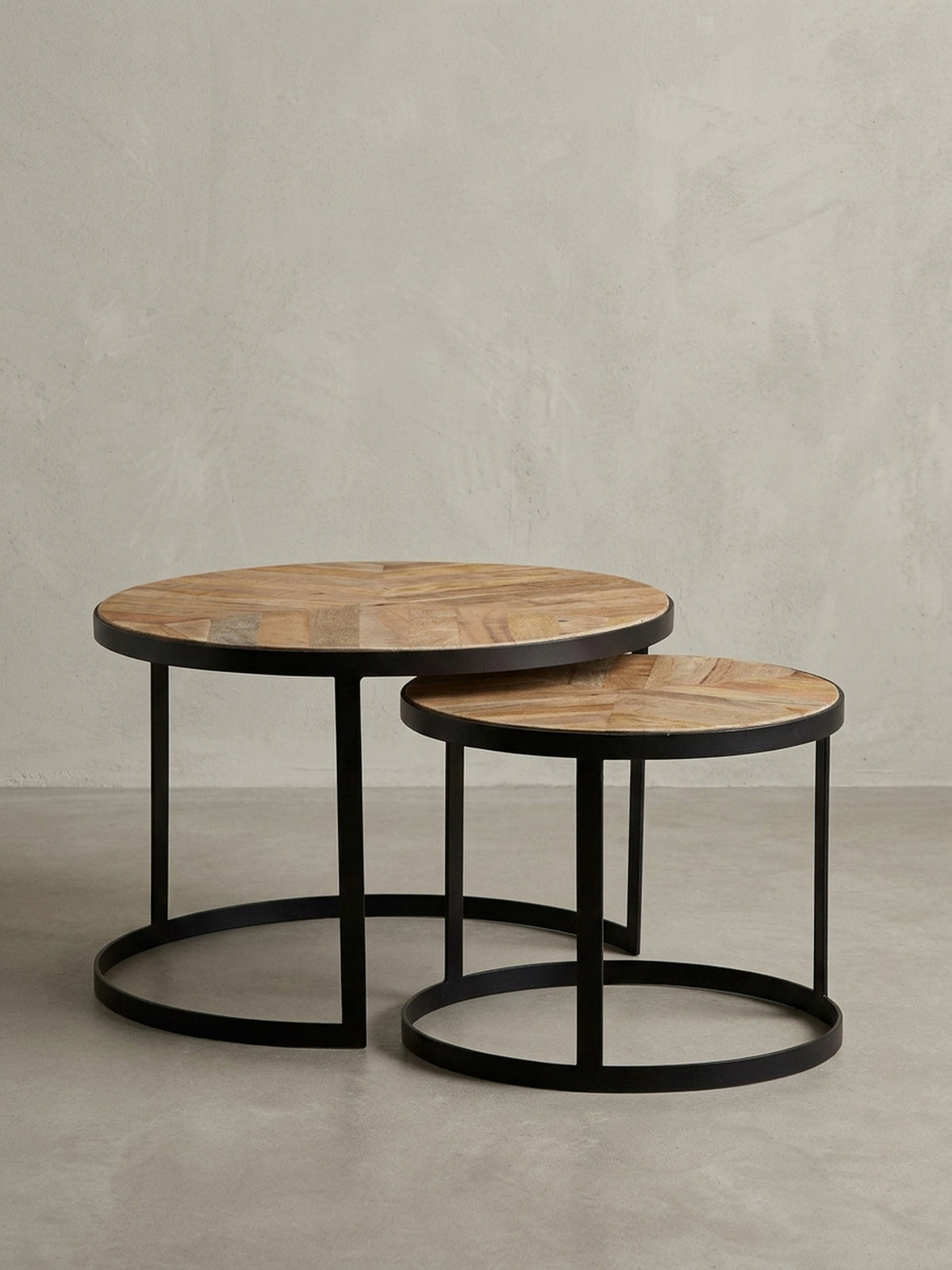 Freigestellter runder Couchtisch als 2er Set, Massivholz-Platten mit schwarzen Metallbeinen im Industrial Stil auf weißem Hintergrund, Frontansicht._