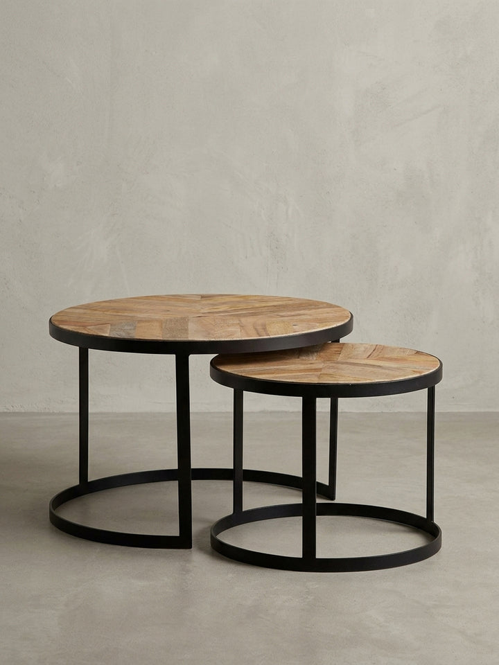 Freigestellter runder Couchtisch als 2er Set, Massivholz-Platten mit schwarzen Metallbeinen im Industrial Stil auf weißem Hintergrund, Frontansicht._