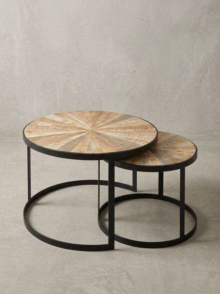 Detailaufnahme des Tischrandes, die die 3 cm starke Metallumrandung und die glatt lackierte Oberfläche des sternförmig gemusterten Mangoholzes darstellt._